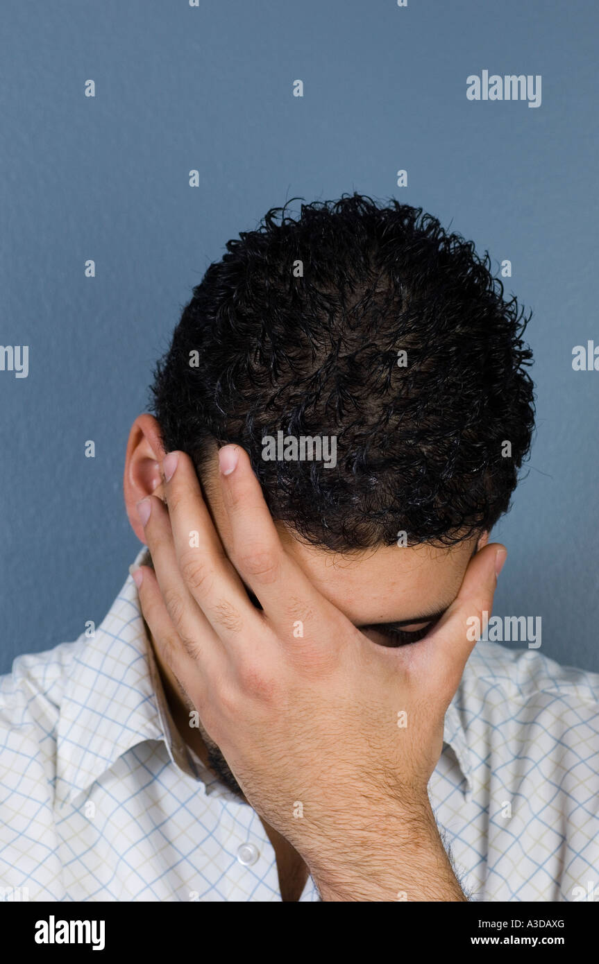 Young man hiding his face in shame Stock Photo
