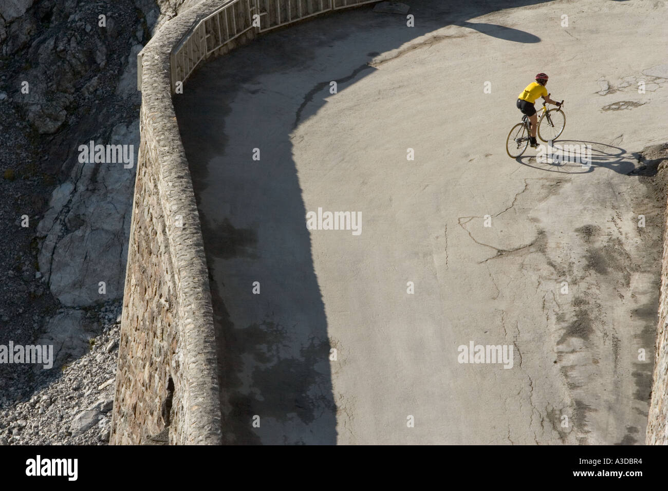 Cyclist on bend of highest road in the Alps to the mountain pass of Stilfserjoch, South Tyrol, Italy Stock Photo