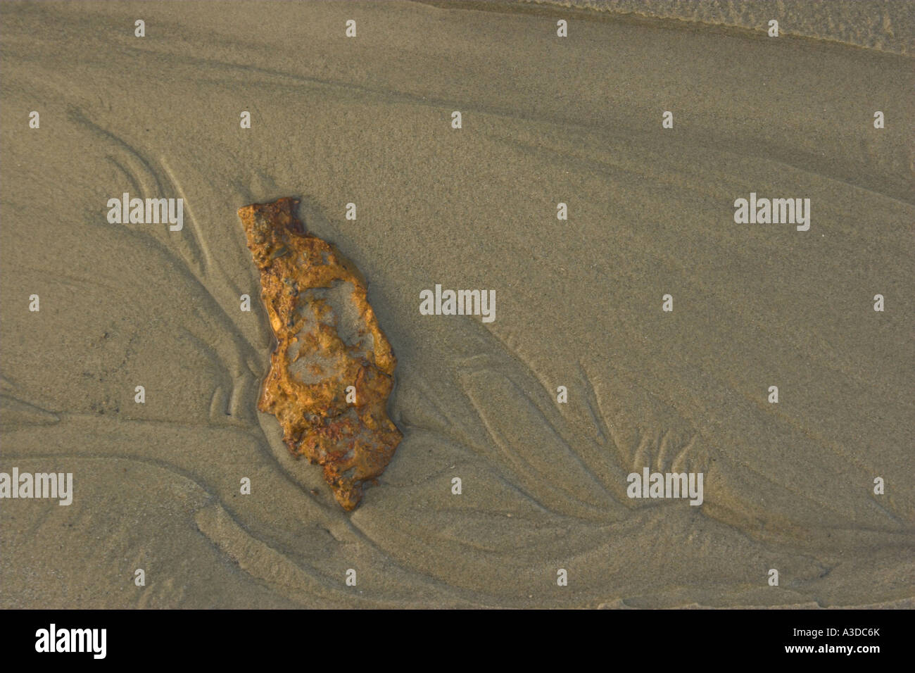 Concept / abstract - A rusting piece of metal on a sandy beach Stock ...
