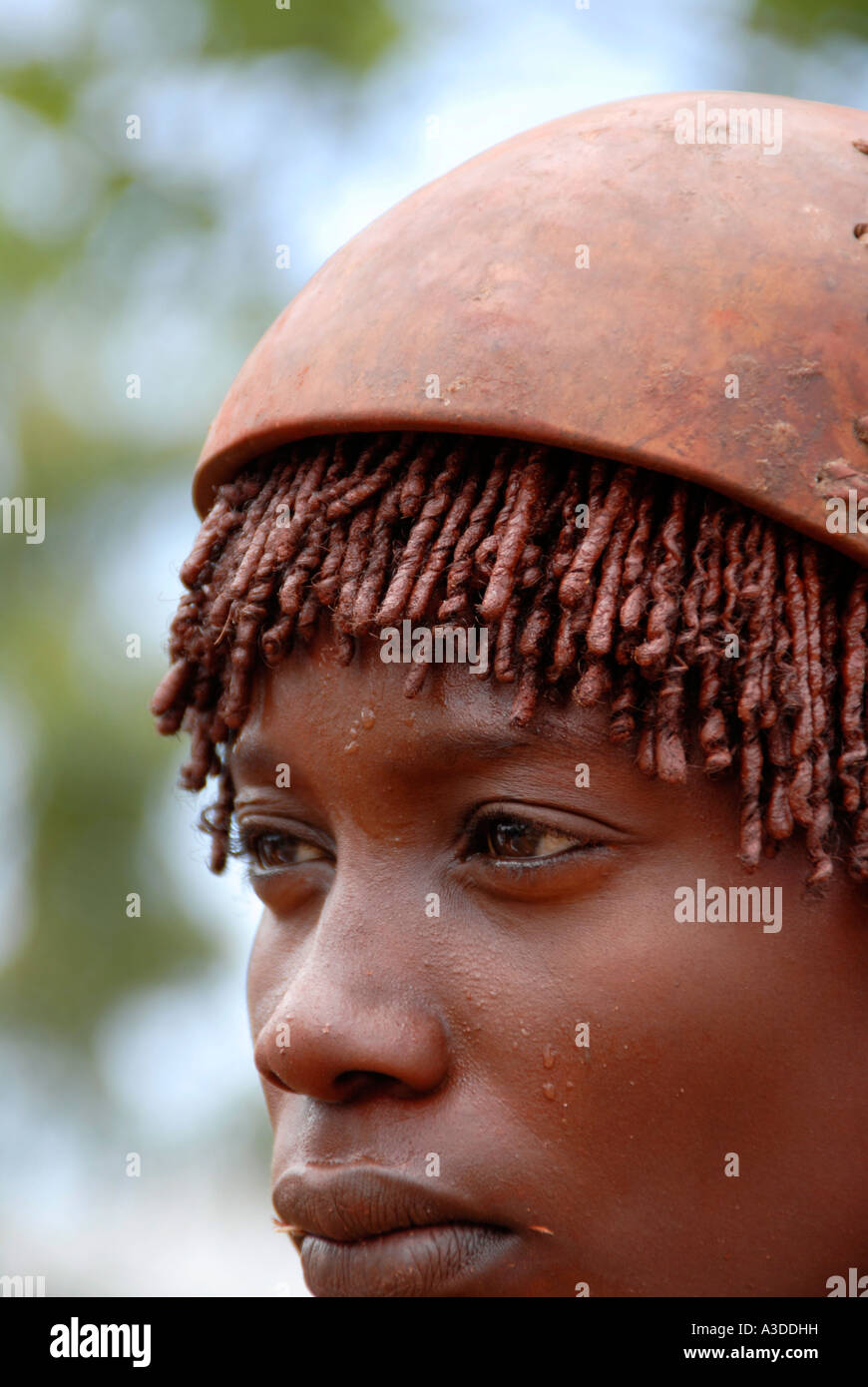 Portrait woman of the Hamar people wears a typical clay hairdo and a kalabasse on her head at the market of Dimeka Ethiopia Stock Photo