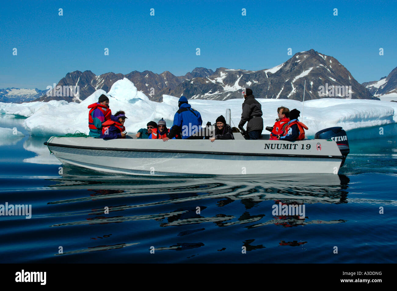 Open motor boat with warm dressed people runs through ice pack