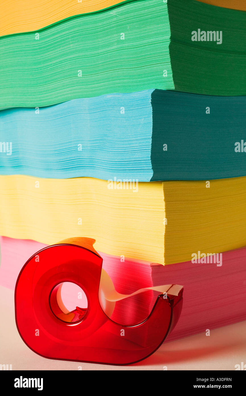 Red tape dispencer and colored paper Stock Photo