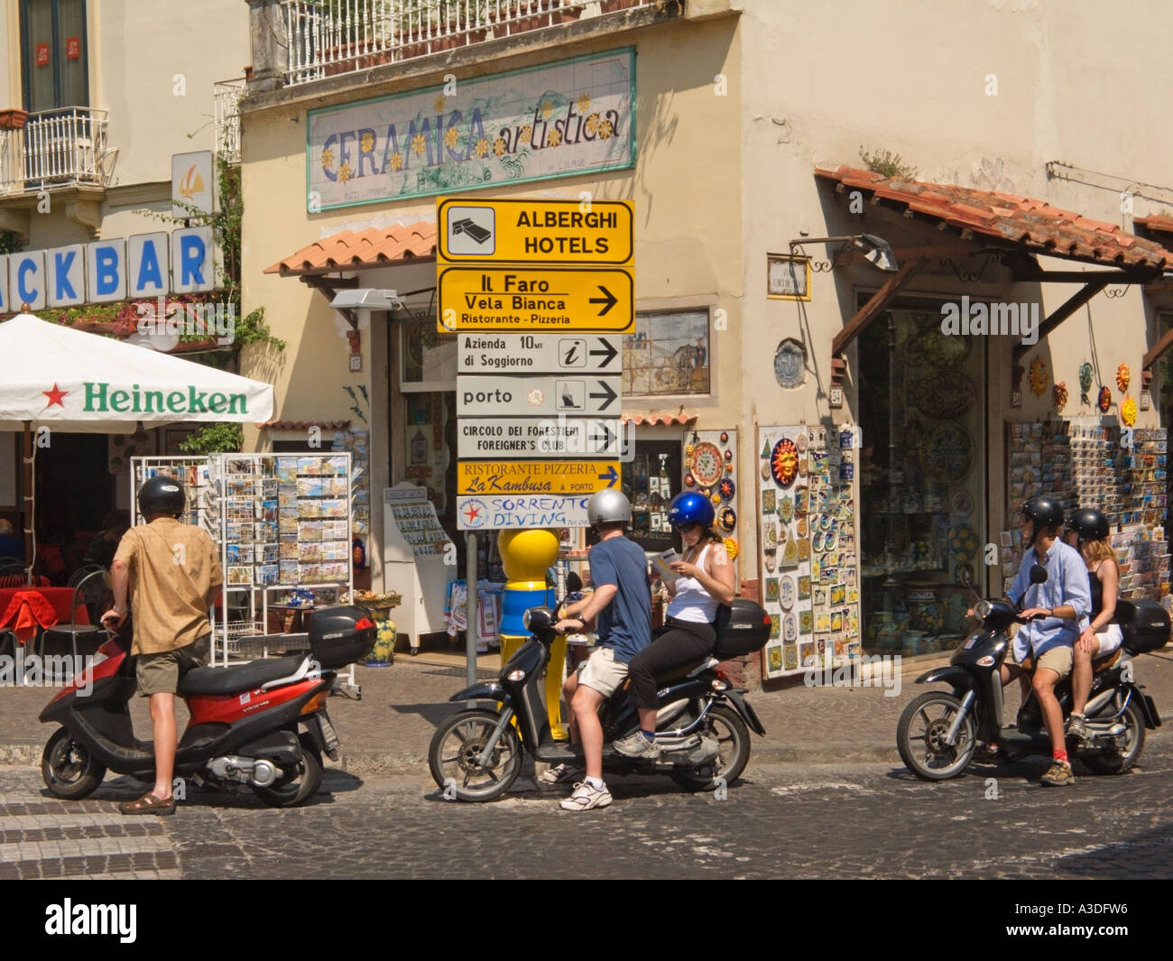 Tourists on riding motor hire bikes Sorrento, Bay of Naples, Italy Stock Photo