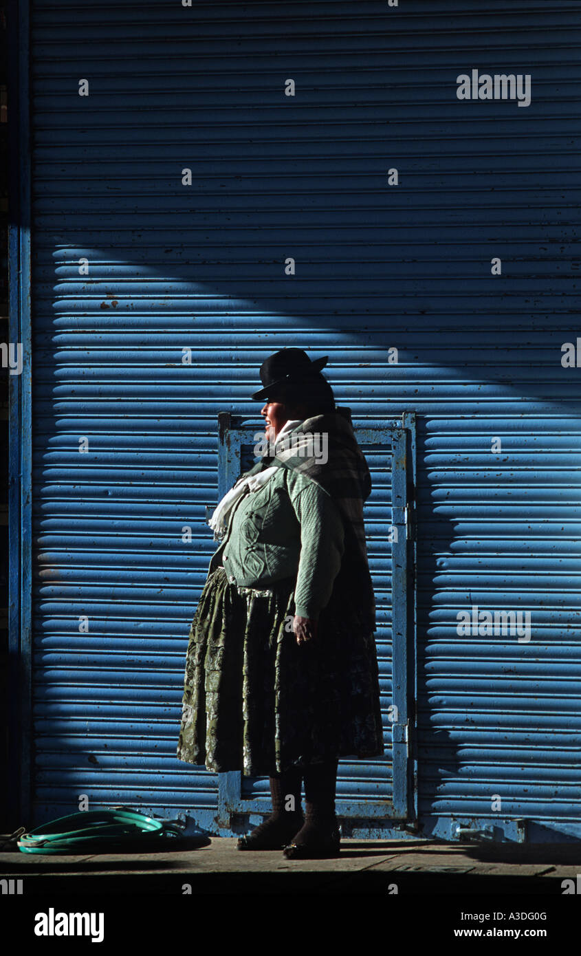 Quechua woman standing against a blue wall Market Puno Lake Titicaca Peru South America Stock Photo