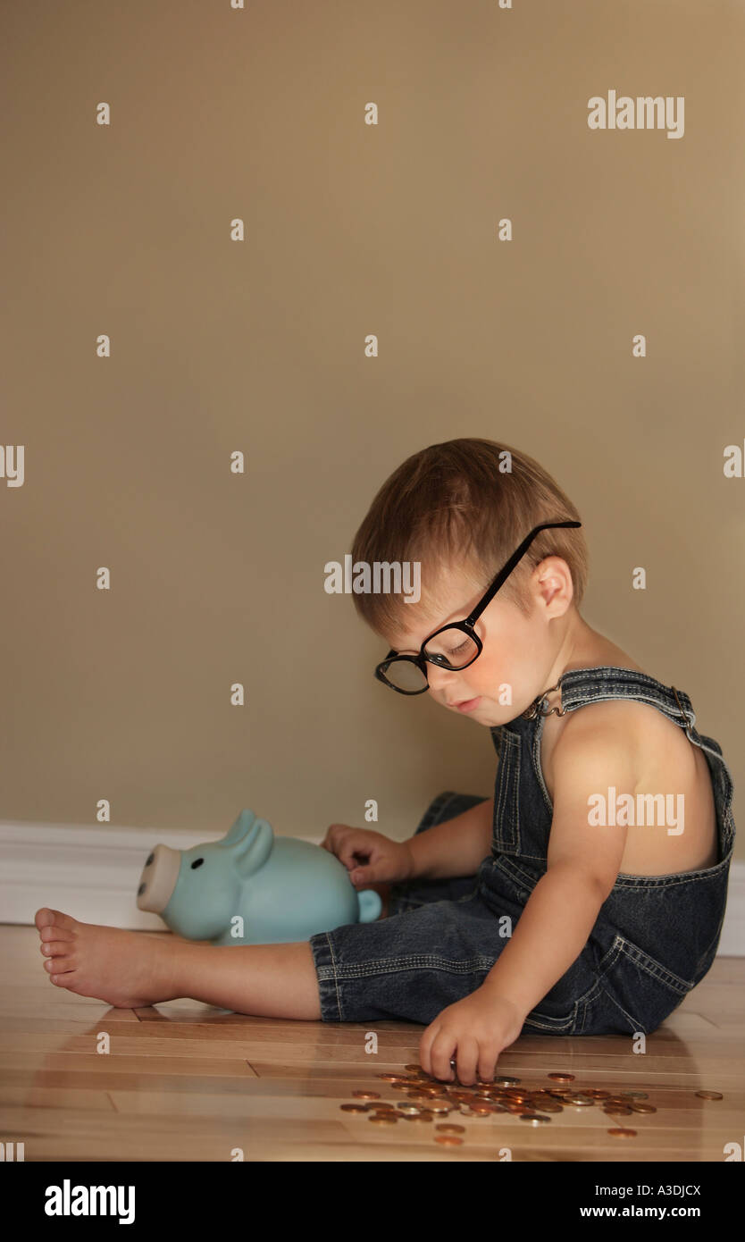Boy putting money into a piggy bank Stock Photo - Alamy