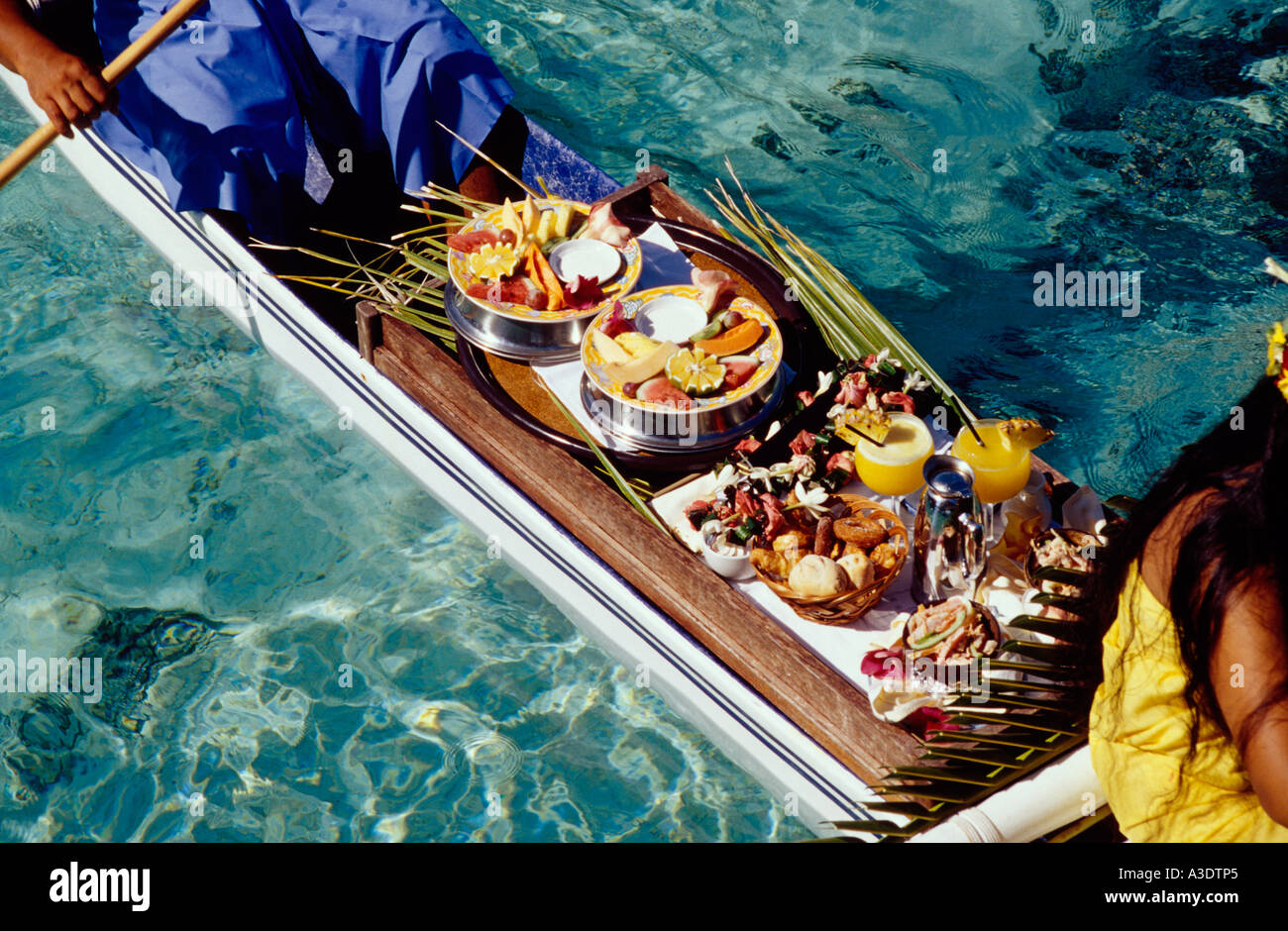 Close-up of breakfast being delivered by two women in traditional dress in  an outrigger canoe, Sheraton Moorea Hotel, Tahiti Stock Photo - Alamy