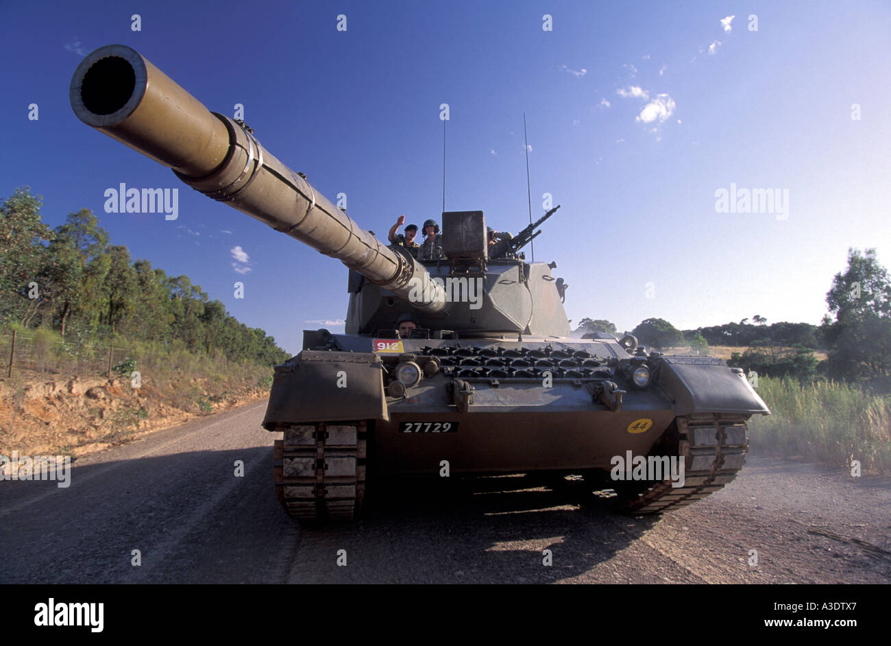Army tank with its gun pointing over camera, soldier directing driver ...