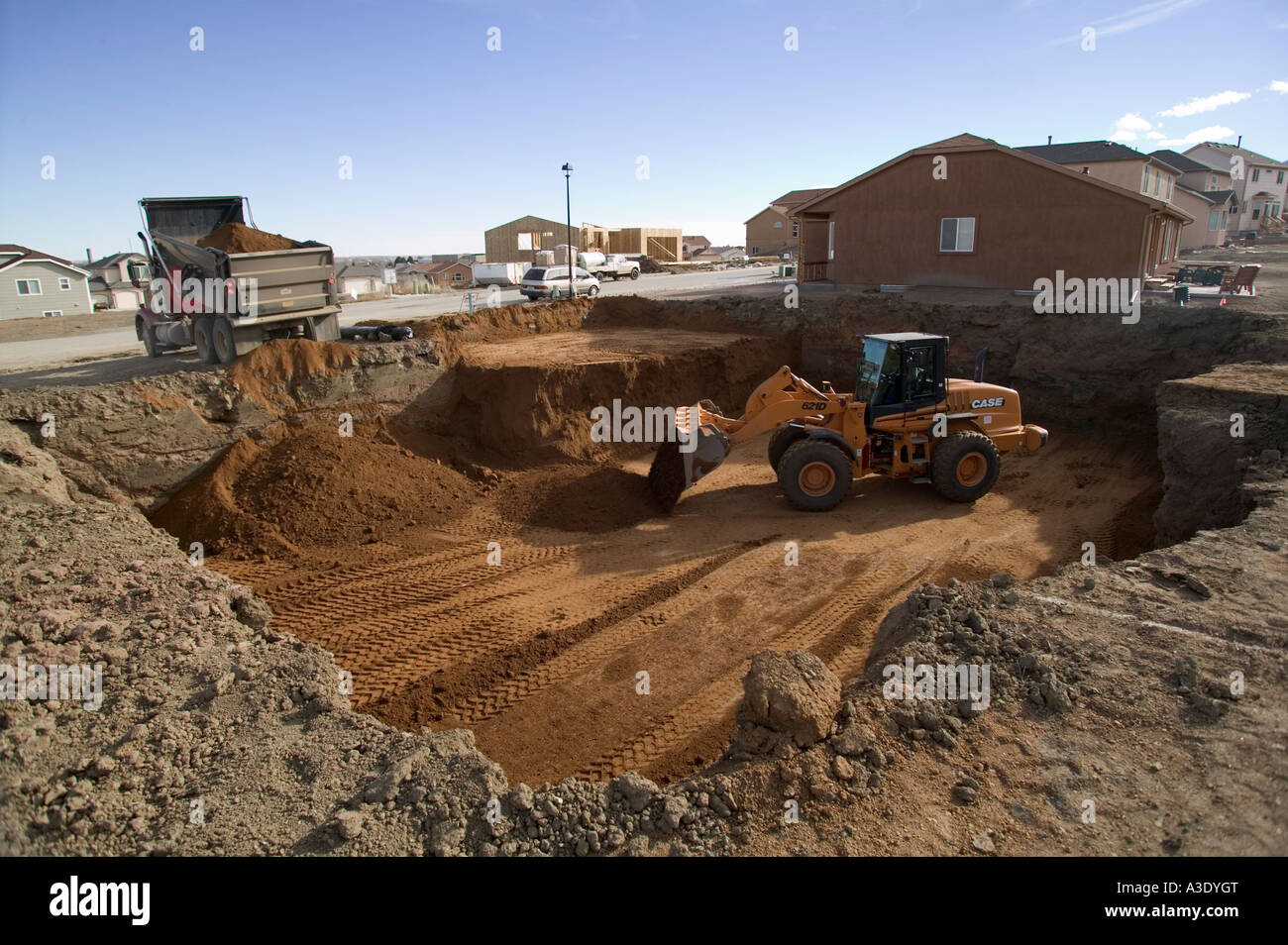 FrontEnd Loader Digging Foundation At Residential Construction Site