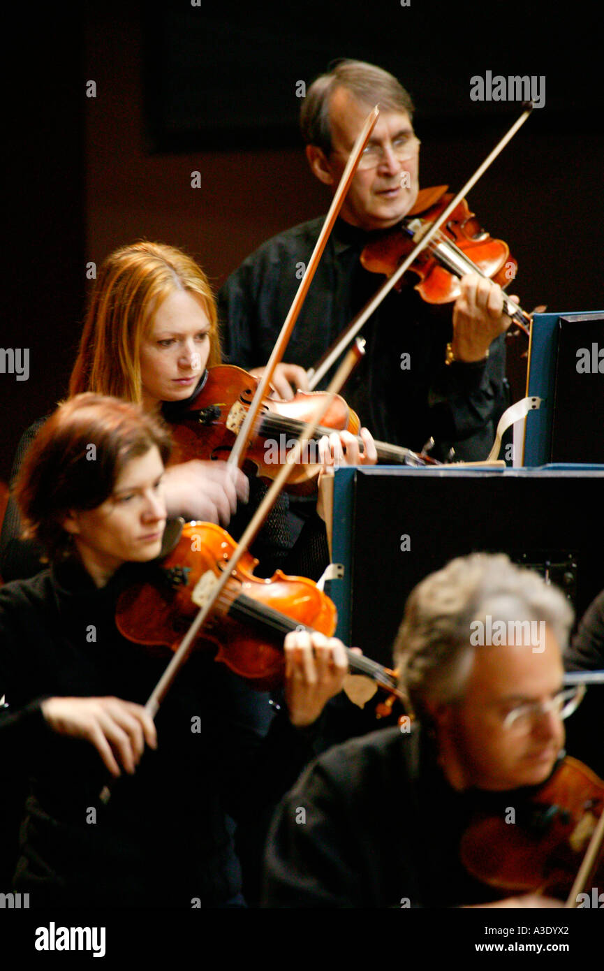 Four violinists, two women and two men, playing in New Zealand Symphony Orchestra Stock Photo