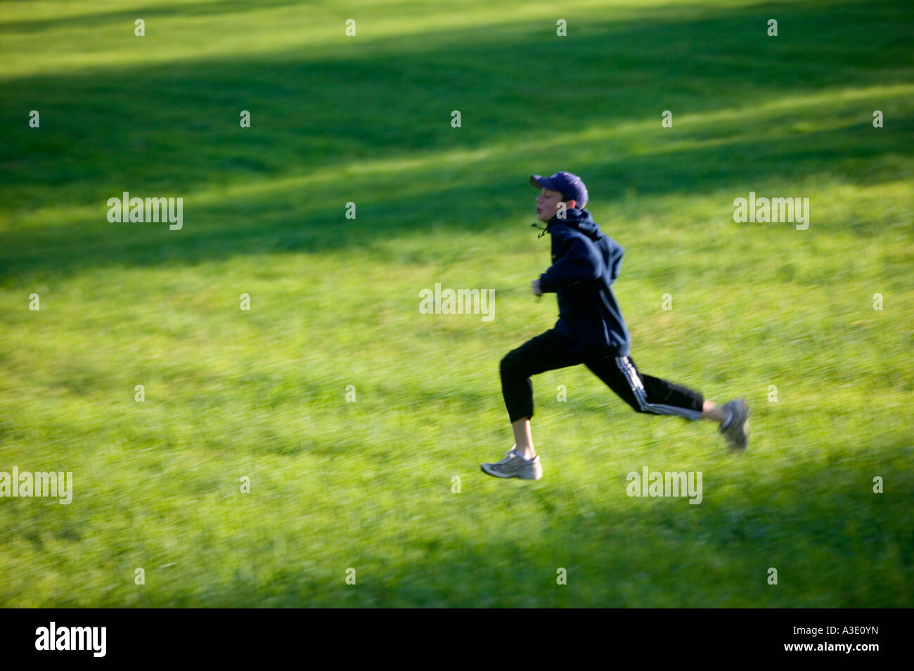 Energetic teenage boy running In springtime green fields Stock Photo ...