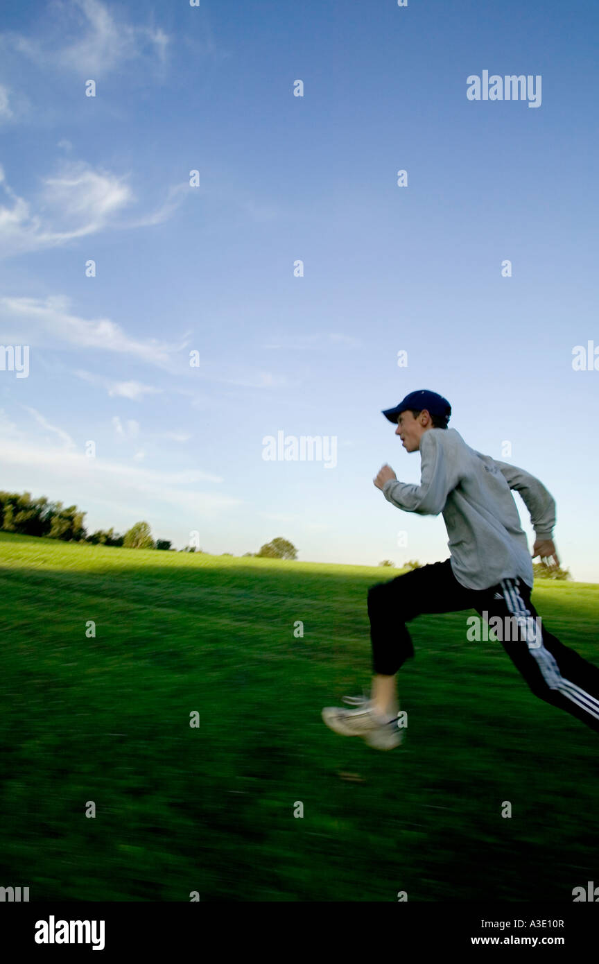 Energetic teenage boy running In springtime green fields Stock Photo ...