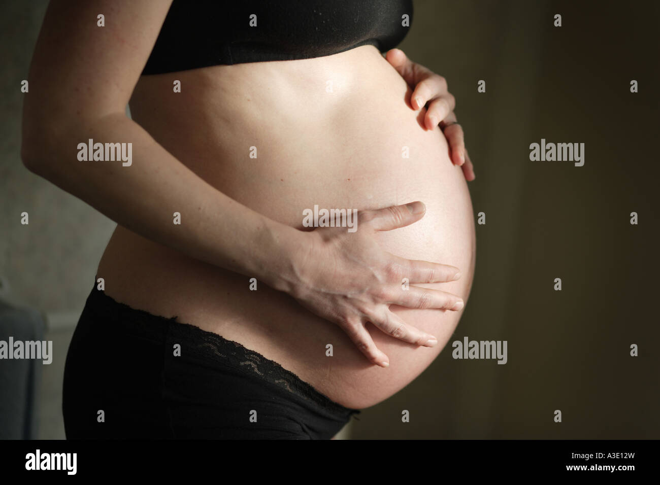 close up of a 9 months pregnant woman showing off her bump Stock Photo