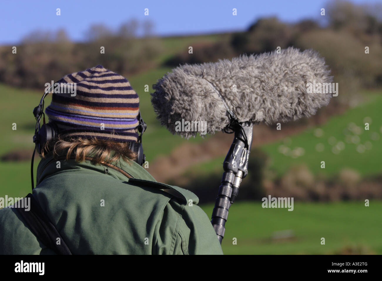 TV television film crew sound recordist sound man with boom microphone working outdoor outside production Stock Photo