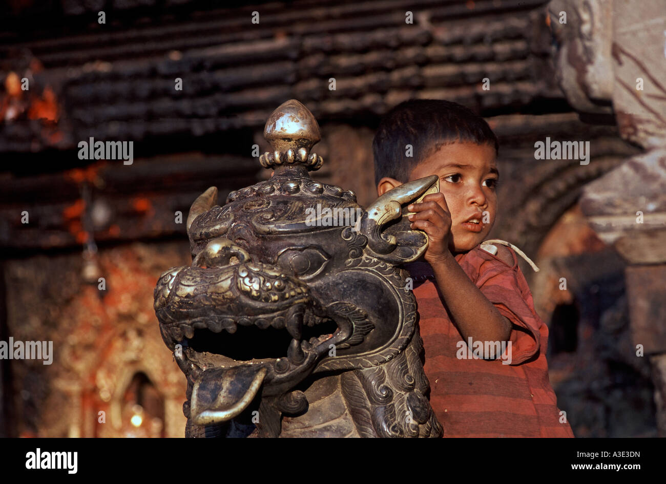 Little boy and bronzelion in front of Bhairava-Temple, Bhaktapur, Nepal Stock Photo