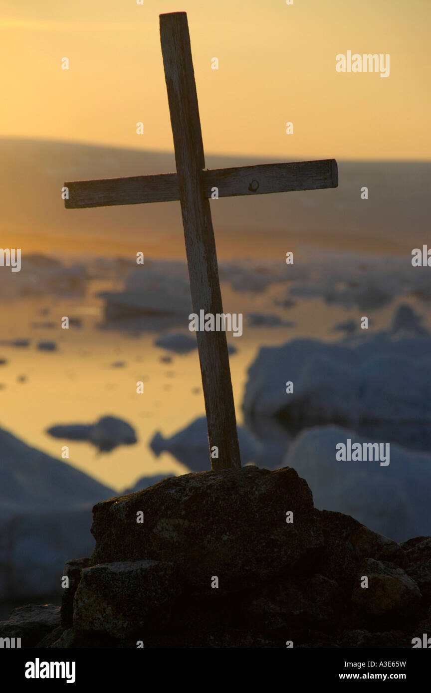 Cross in front of sunset over icebergs Paarnakajiit Sermilik Fjord ...