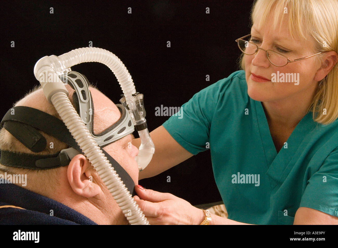 Nurse hooking up a Continuous Positive Airway Pressure CPAP machine Stock Photo