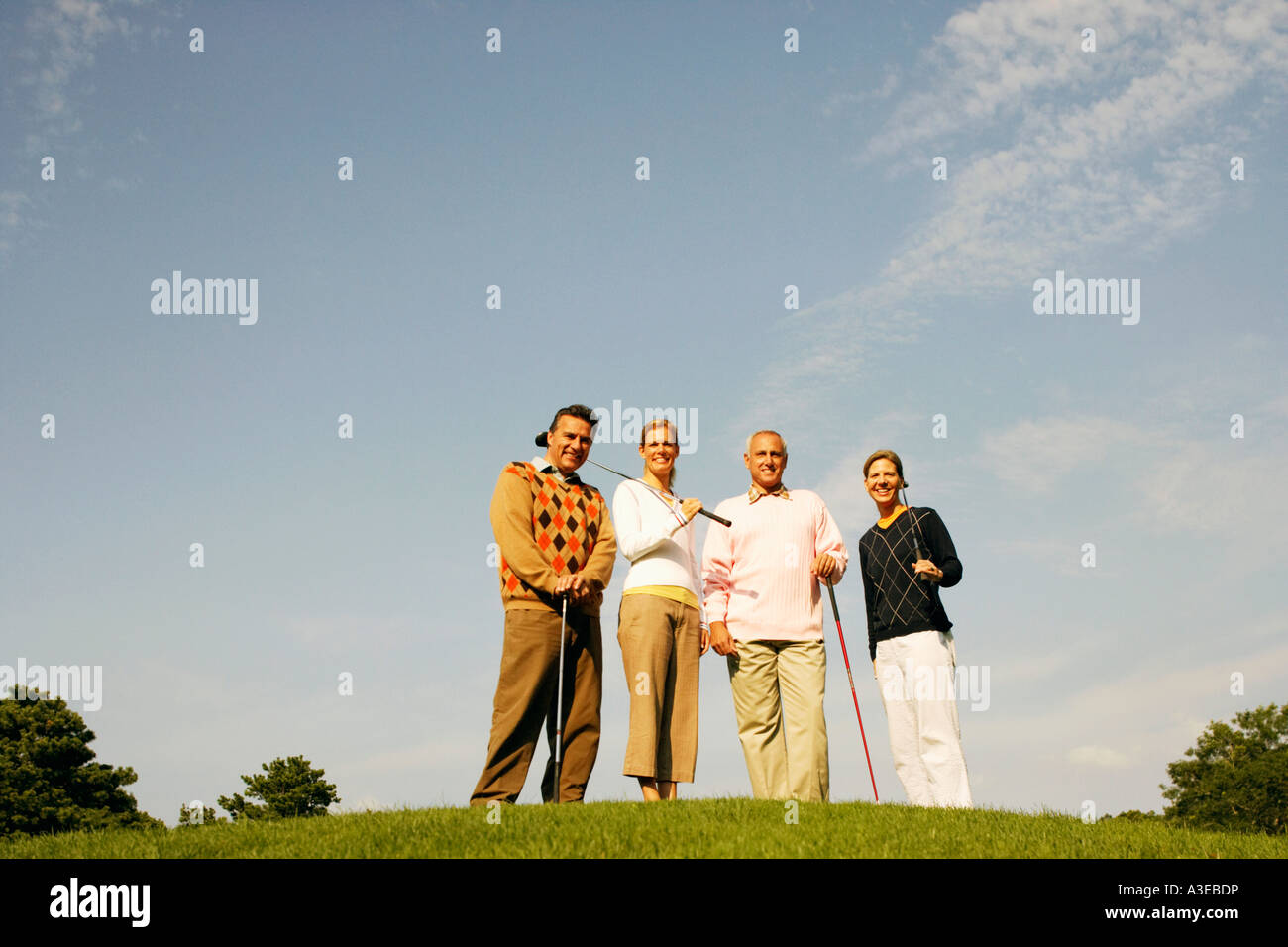 Portrait of two couples standing on a golf course Stock Photo