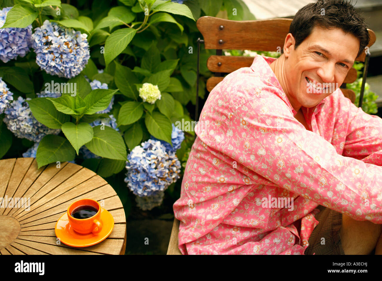 Portrait of a mature man sitting on a chair and smiling Stock Photo - Alamy
