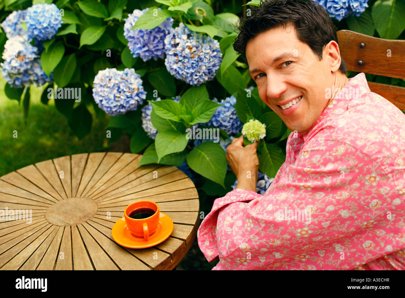 Portrait of a mature man sitting on a chair and smiling Stock Photo - Alamy