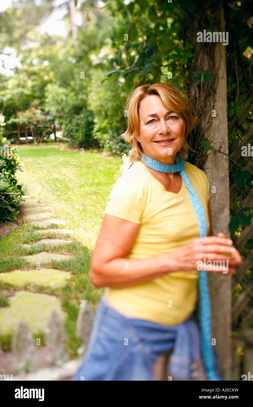Portrait of a mature woman standing and smiling in a park Stock Photo ...