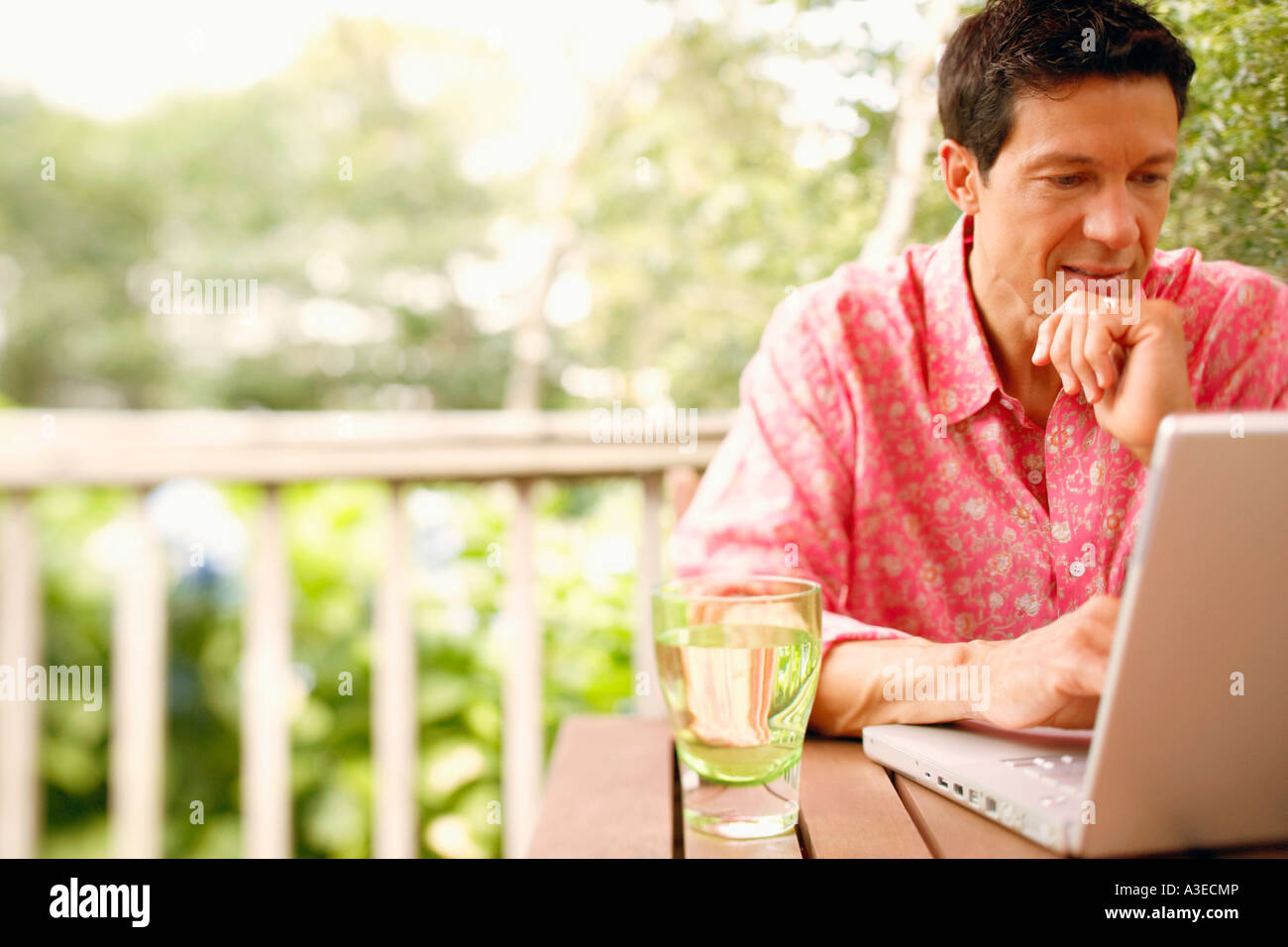 Man sitting on patio using laptop hi-res stock photography and images ...
