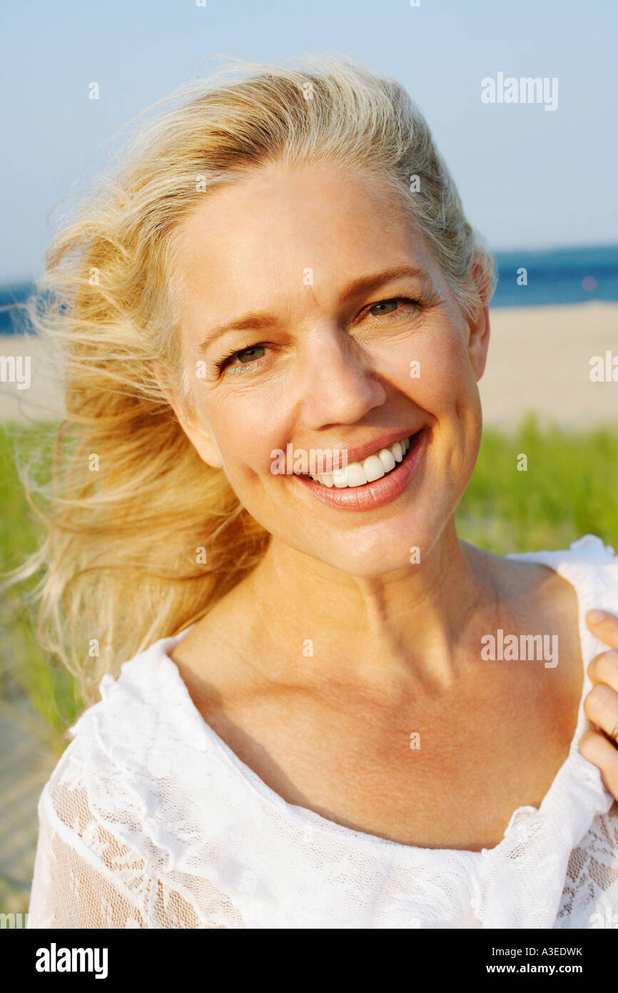Portrait of a mature woman smiling on the beach Stock Photo - Alamy