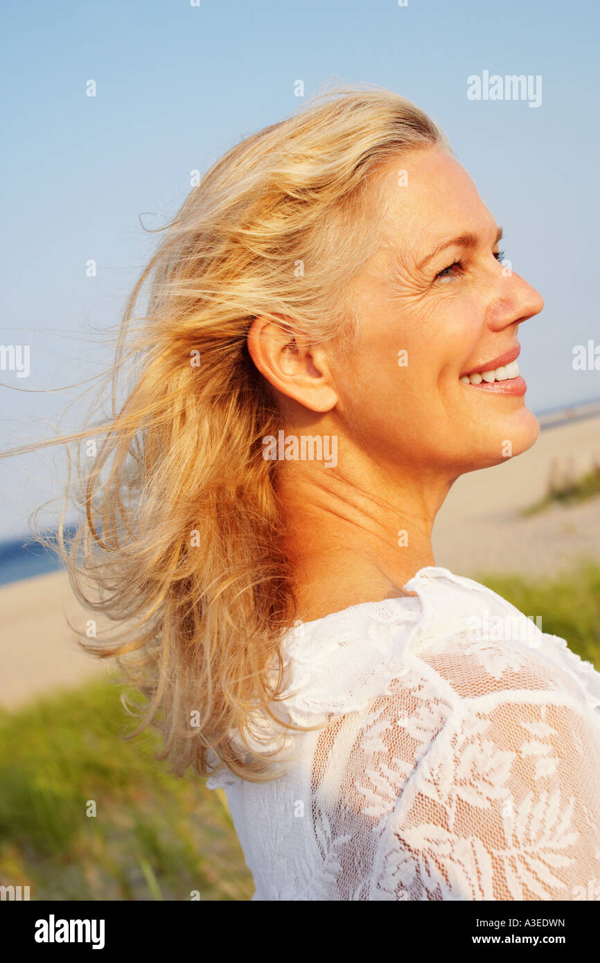 Side profile of a mature woman smiling on the beach Stock Photo - Alamy