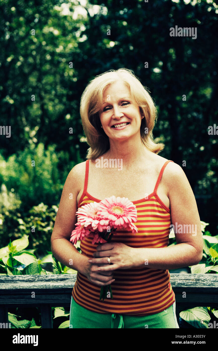 Portrait of a mature woman holding a bunch of flowers Stock Photo - Alamy