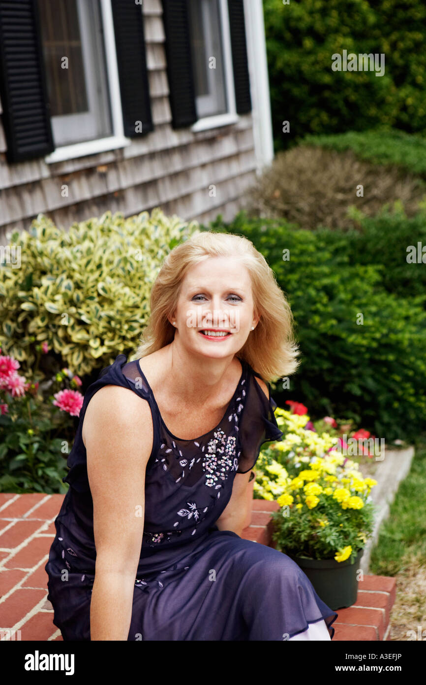 Portrait of a mature woman sitting on the front porch and smiling Stock ...