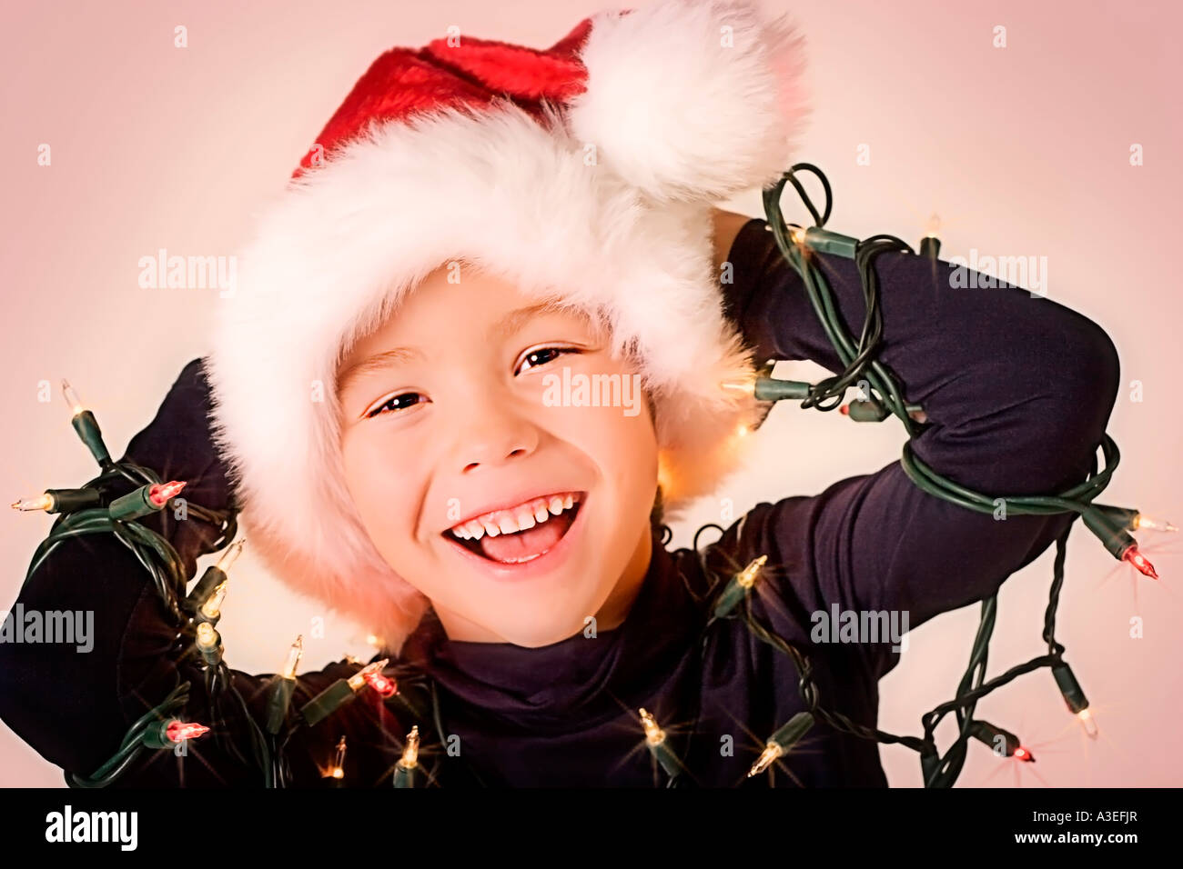 Young boy wrapped in Christmas lights Stock Photo Alamy
