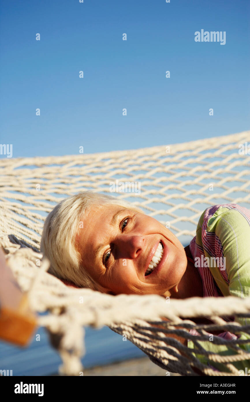 Portrait of a mature woman lying in a hammock and smiling Stock Photo ...