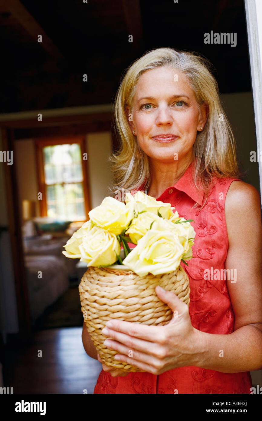 Portrait of a mature woman holding flowers in a vase Stock Photo - Alamy