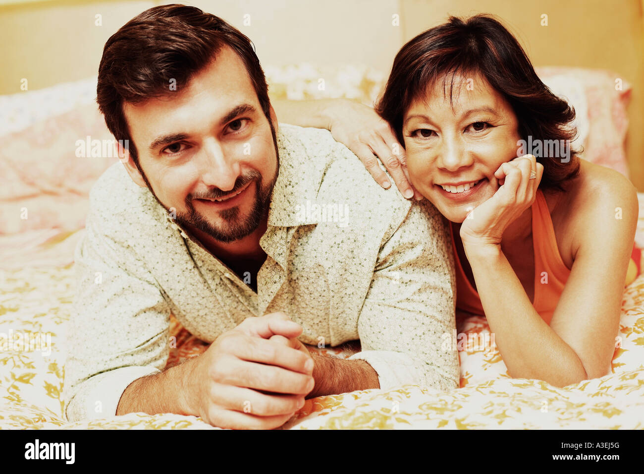 Portrait of a mature couple lying on the bed and smiling Stock Photo ...