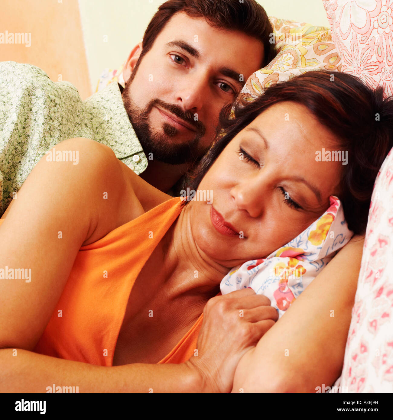 Close-up of a mature woman sleeping with a mature man lying behind her Stock Photo