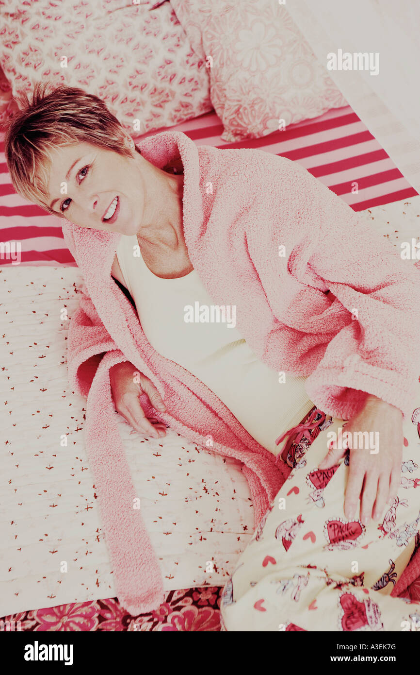 Portrait of a mature woman lying on the bed and smiling Stock Photo - Alamy