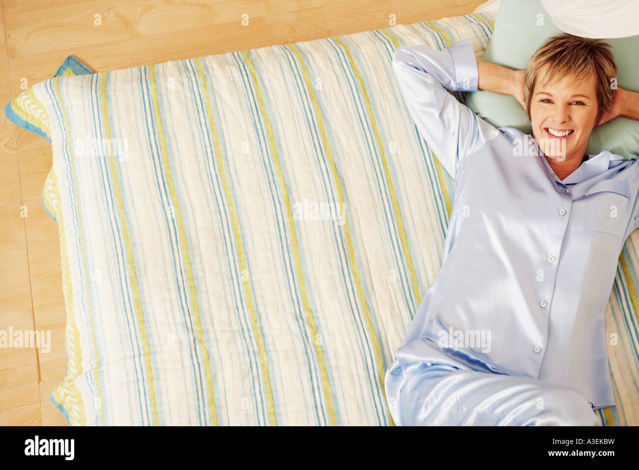 Portrait of a mature woman lying in bed and smiling Stock Photo - Alamy