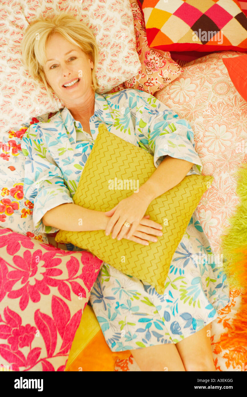 Portrait of a mature woman lying on the bed and smiling Stock Photo - Alamy