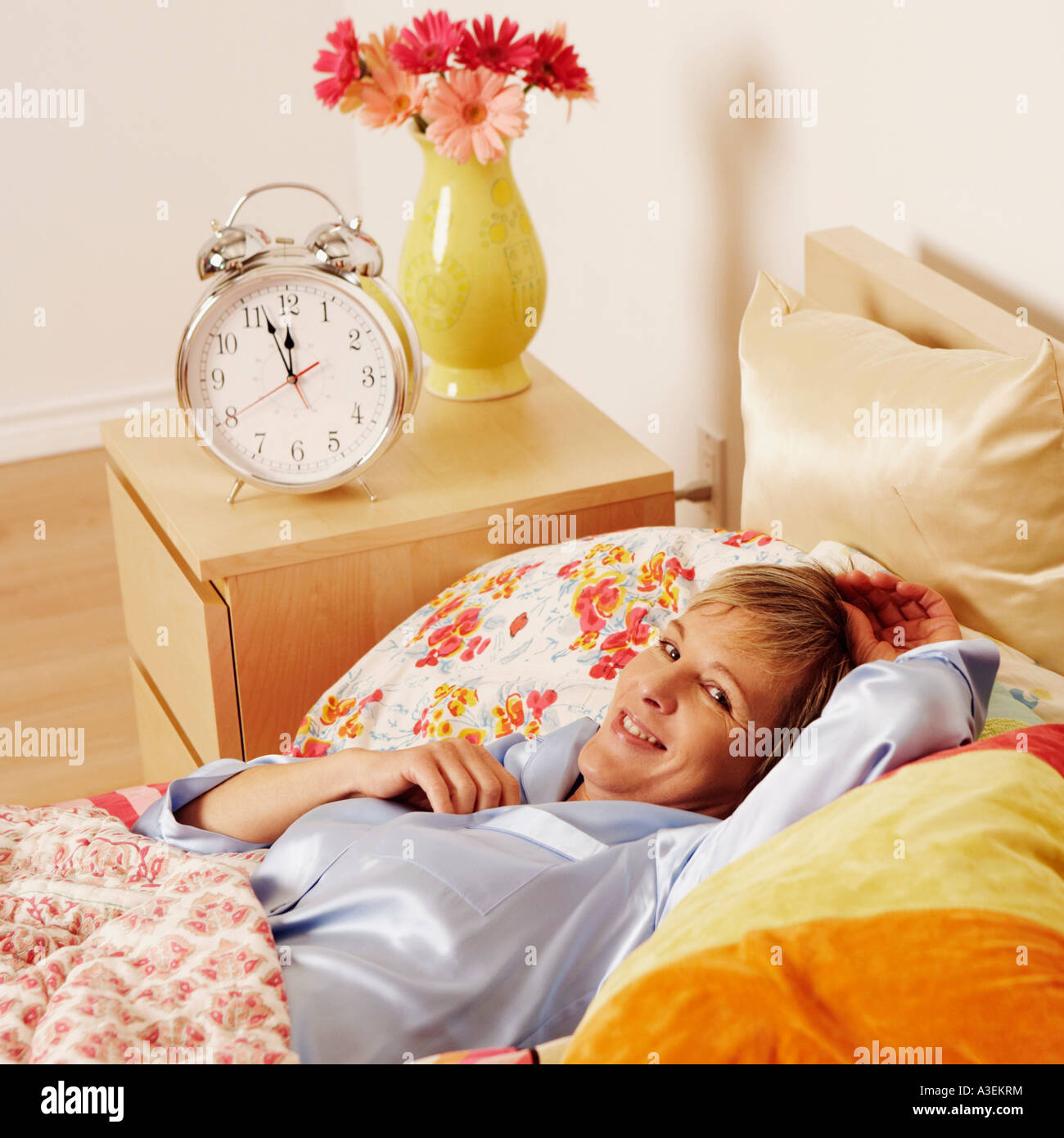Portrait of a mature woman lying in bed and smiling Stock Photo - Alamy