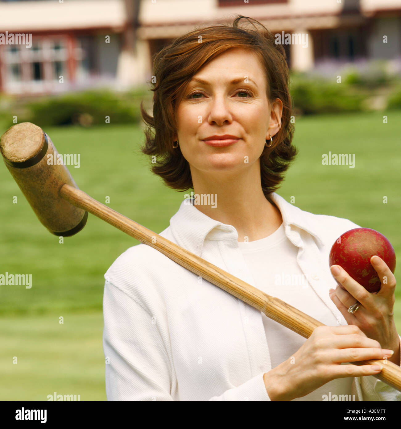 Portrait of a mid adult woman holding a croquet mallet and a ball Stock