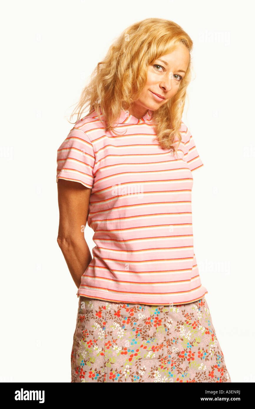 Portrait of a mature woman standing with her hands behind her back ...