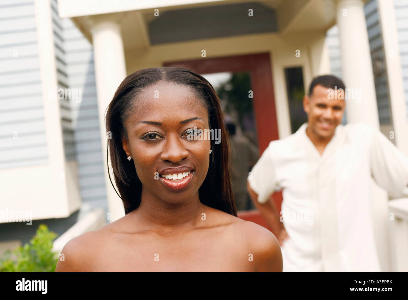 Portrait of a mid adult woman smiling with a mature man standing behind ...