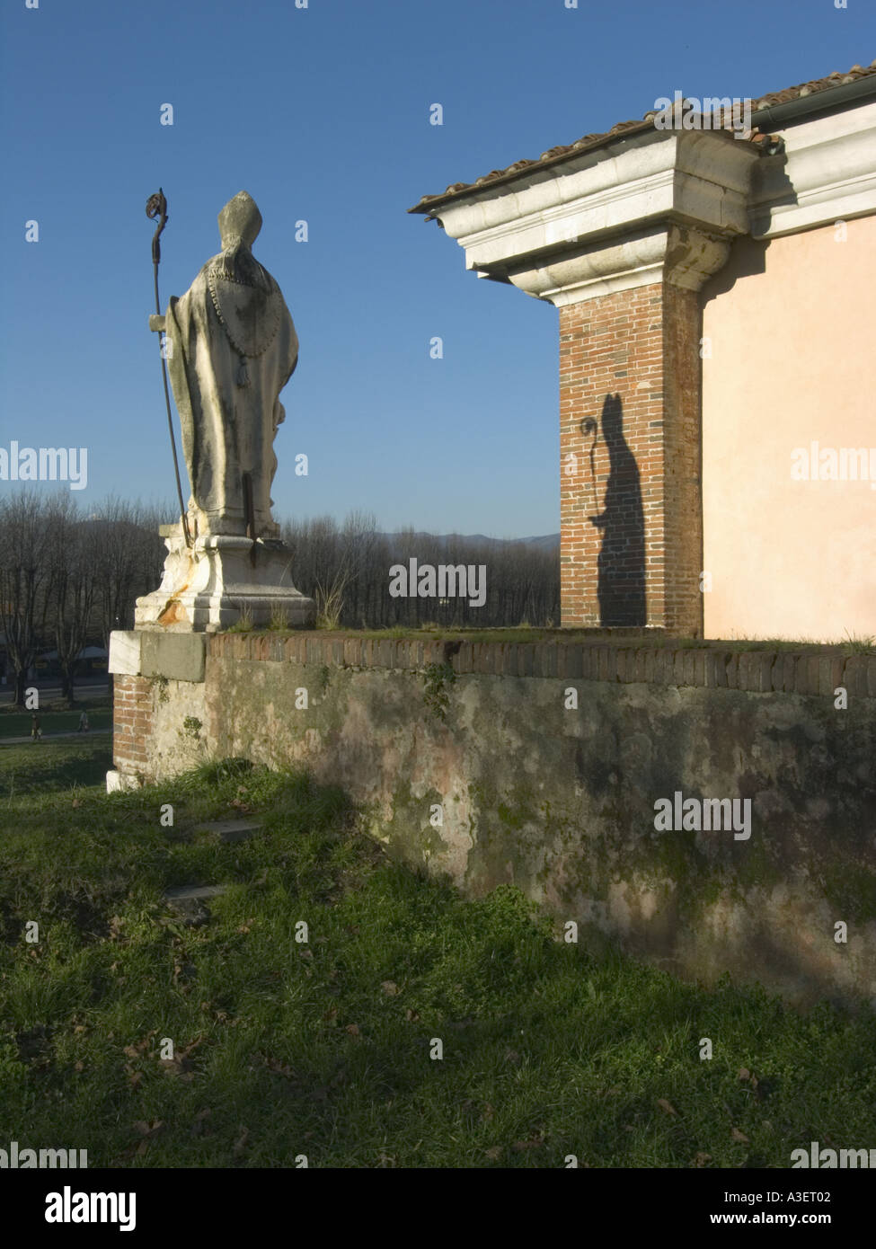 The city walls Lucca Italy Light and shadow evening sunlight statue of the Pope Stock Photo