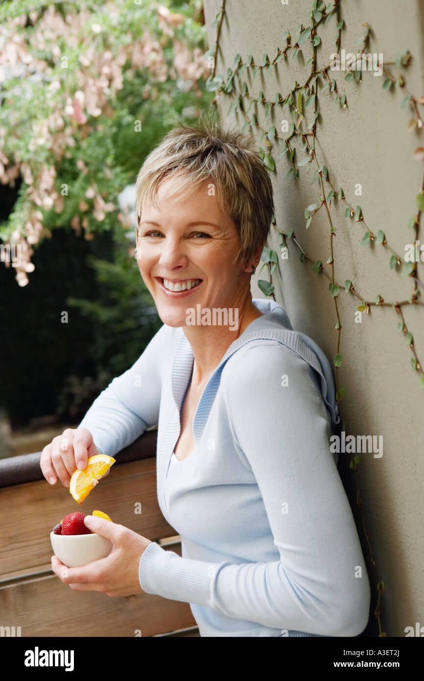 Portrait of a mature woman smiling and holding a bowl of fruit Stock ...