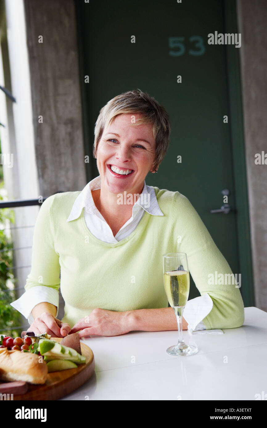 Portrait of a mature woman sitting at the table and smiling Stock Photo ...