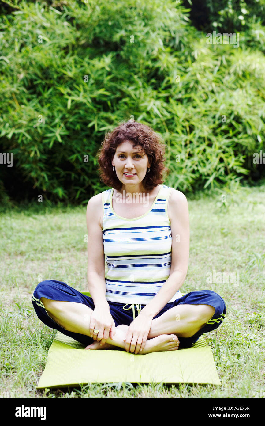 Mature woman exercising on the lawn Stock Photo