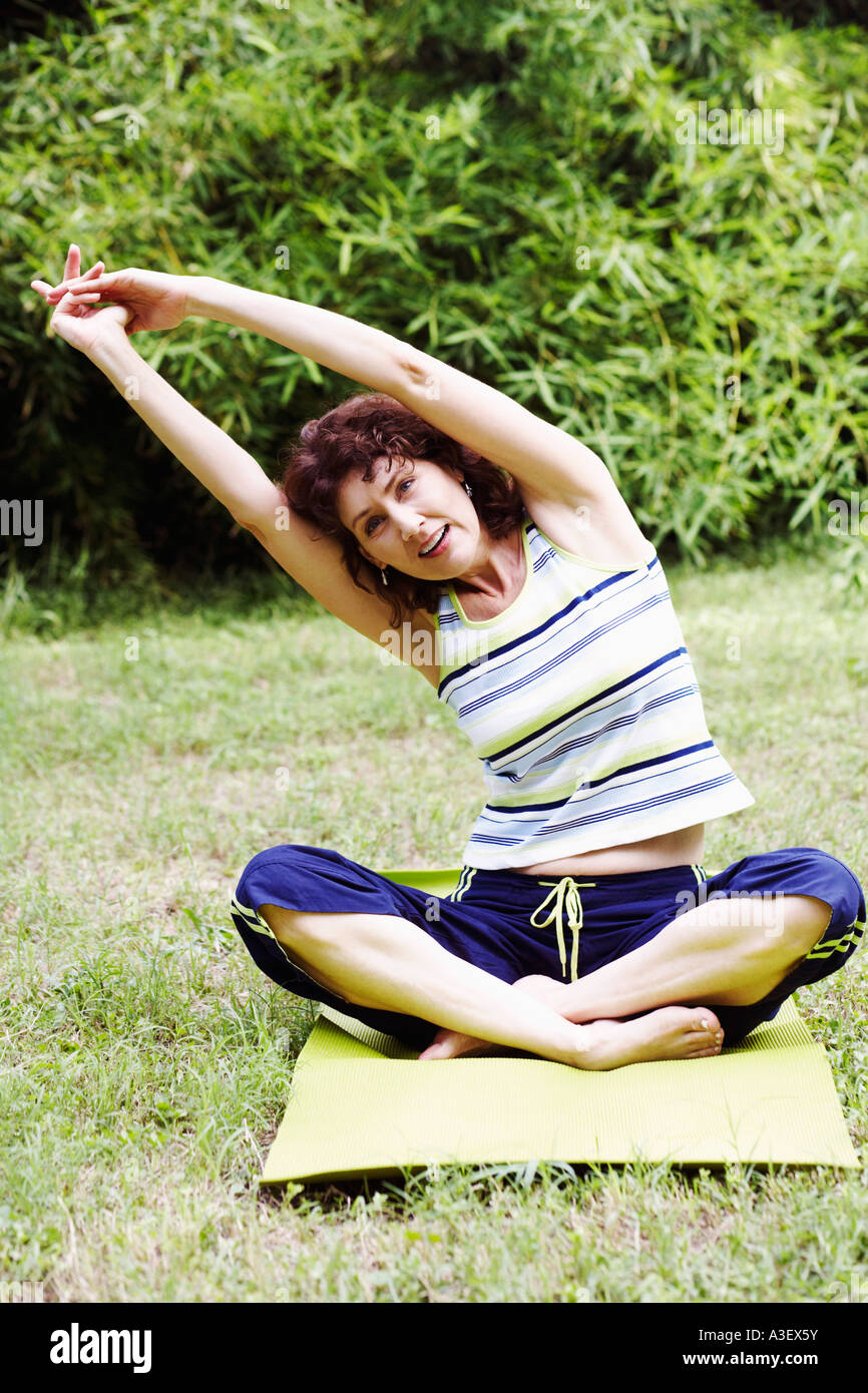 Mature woman exercising on the lawn Stock Photo