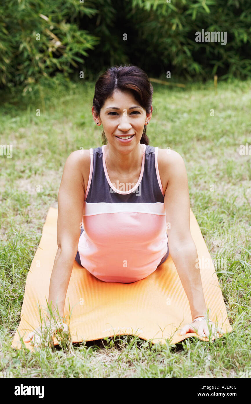Portrait of a mature woman doing yoga on the lawn Stock Photo