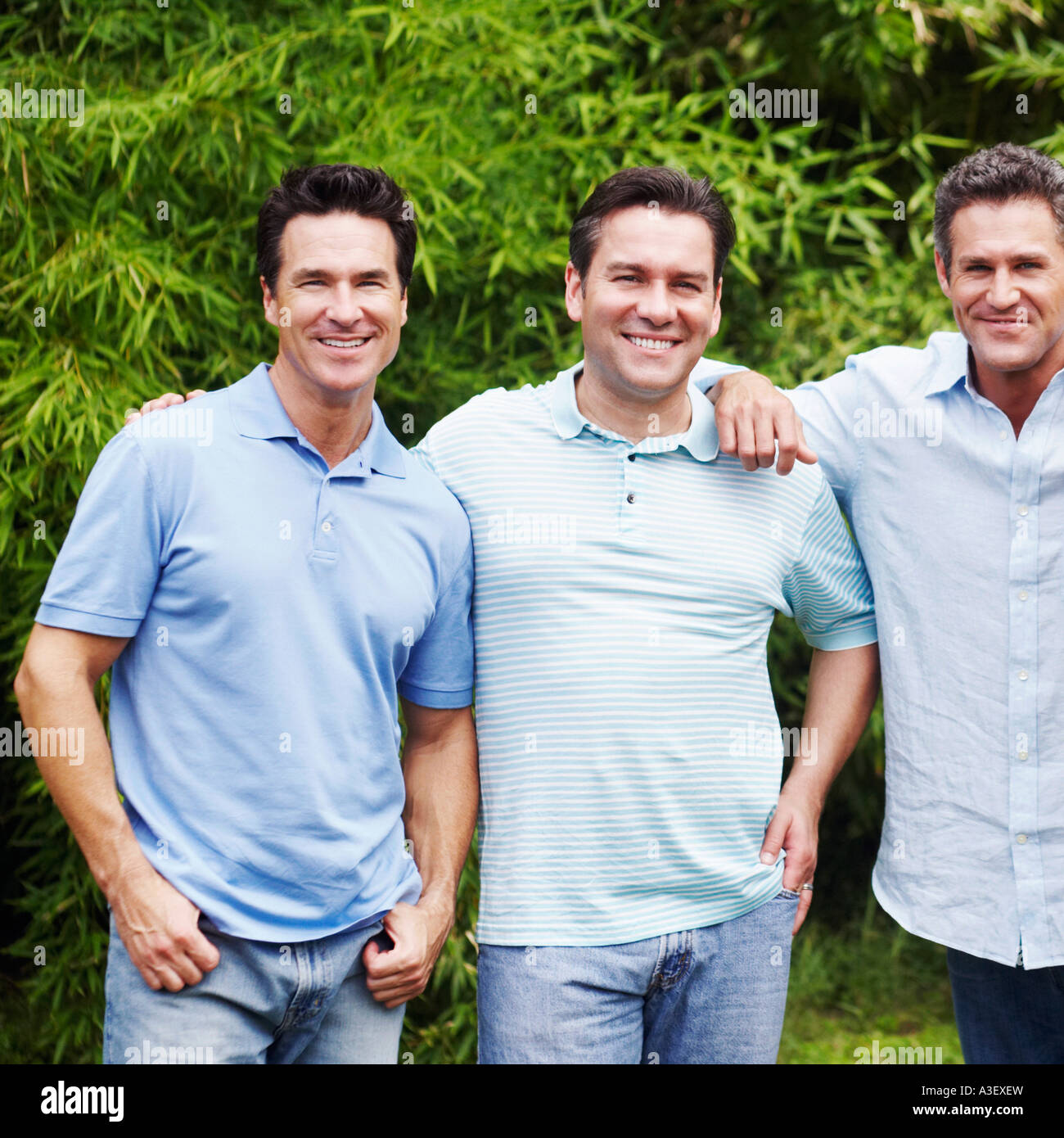 Portrait of a mid adult man with two mature men smiling Stock Photo - Alamy