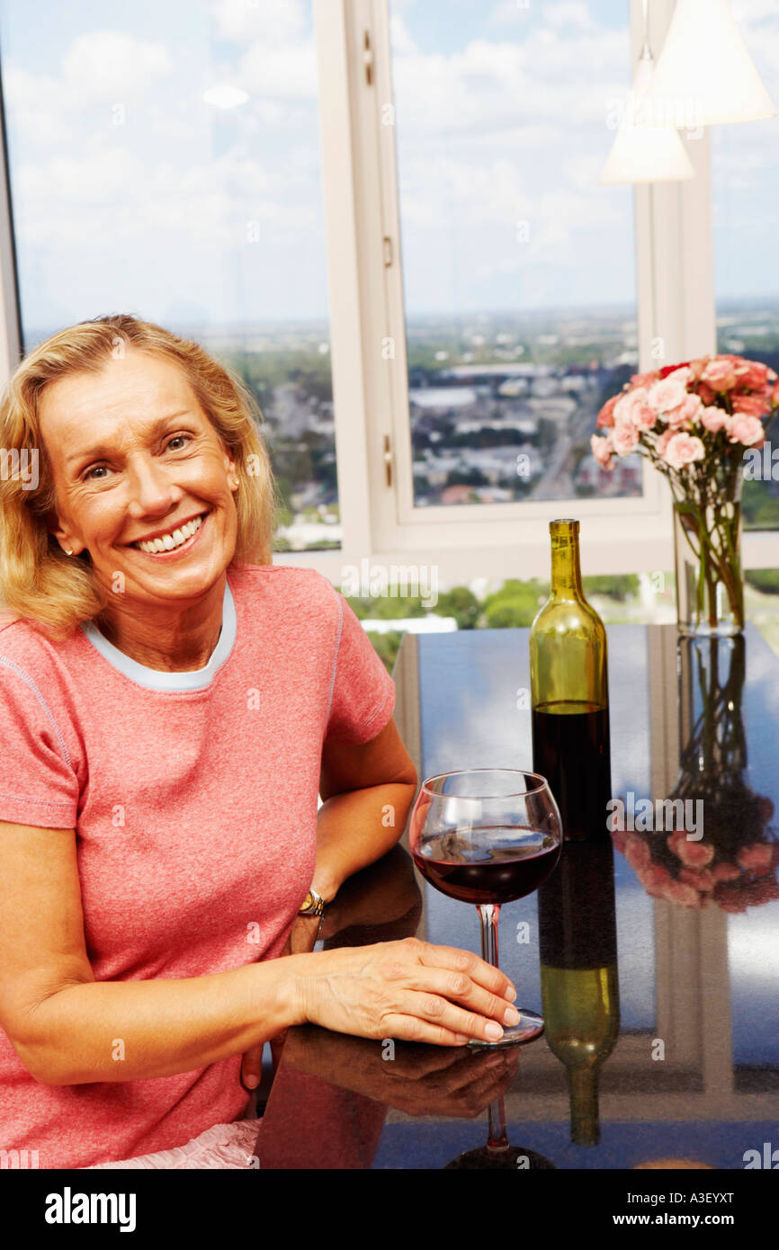 Portrait of a mature woman holding a glass of wine and smiling Stock ...
