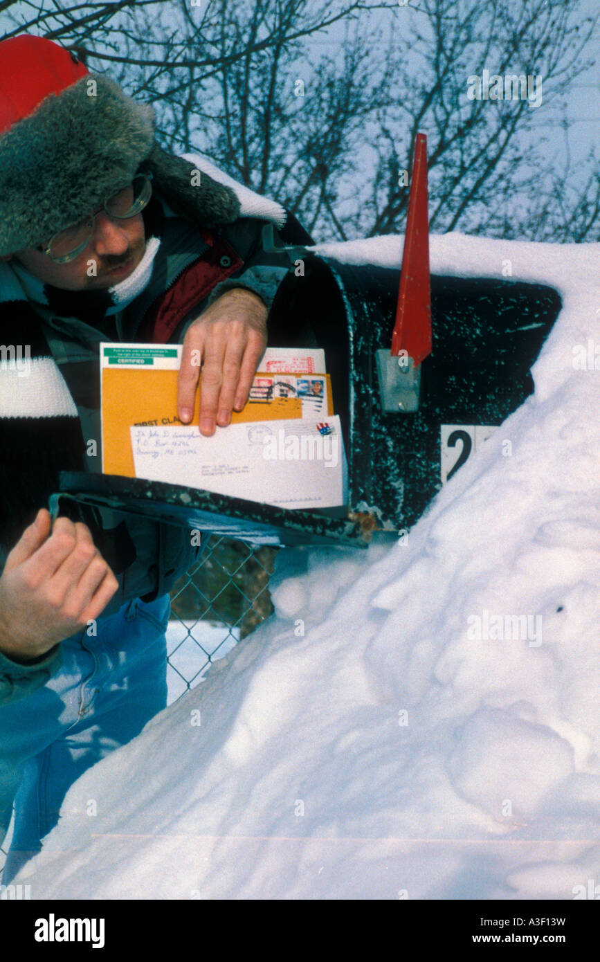 Man getting mail from snowbound mailbox America USA Stock Photo
